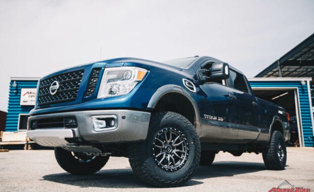 2017 Nissan Titan XD Icon suspension on Fuel Offroad REBEL 6 18x9 +20mm and LT295/70R18/10 129/126R FAL WILDPEAK A/T3W front driver side grille view