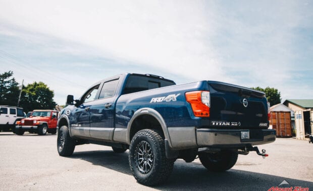 2017 Nissan Titan XD Icon suspension on Fuel Offroad REBEL 6 18x9 +20mm and LT295/70R18/10 129/126R FAL WILDPEAK A/T3W rear driver side tailgate view