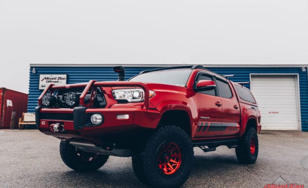 17 Tacoma fox 2.5 coilover suspension on 17x9 6x5.5 106.1 Candy Red Covert Fuel MHT -12mm and Nitto Ridge Grappler 33x12.50R17 tires front driver side grille view