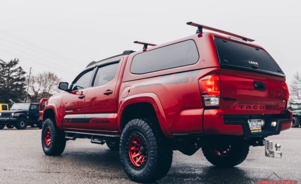 17 Tacoma fox 2.5 coilover suspension on 17x9 6x5.5 106.1 Candy Red Covert Fuel MHT -12mm and Nitto Ridge Grappler 33x12.50R17 tires rear driver side tailgate view
