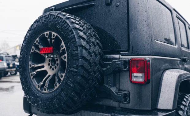 Grey 2018 Jeep Wrangler with fuel wheels 5th wheel tire carrier rear tailgate view close up