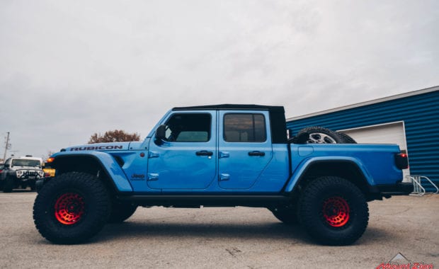 Blue Jeep Gladiator soft top with Red fuel wheels driver side view
