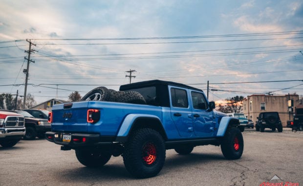 Blue Jeep Gladiator soft top with Red fuel wheels rear passenger side tailgate view