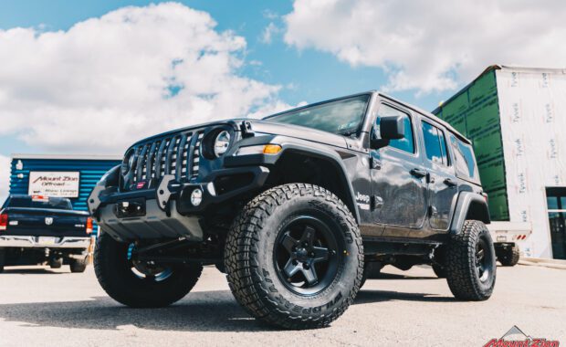 2019 Jeep Wrangler with AEV N0724100AA 2.5in suspension on AEV 20402034AA Pintler Wheel In Matte Black and 35X12.50R17 Falken Wildpeak AT3W front grille driver side view