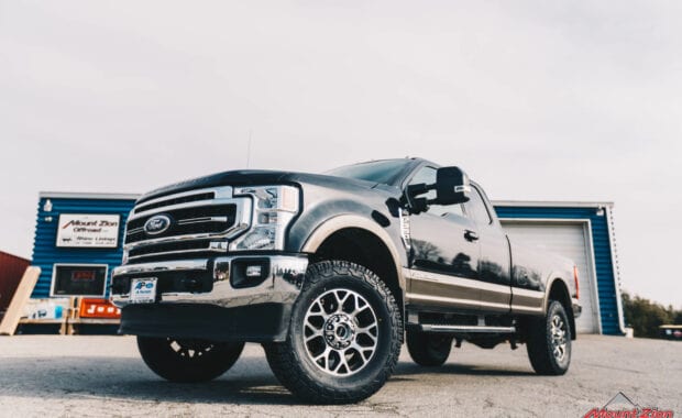 2020 Black F-350 with readylift 2.5 leveling kit and geolander tires front driver side grille view