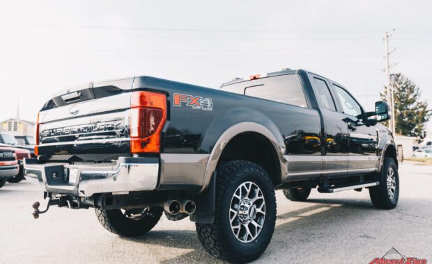 2020 Black F-350 with readylift 2.5 leveling kit and geolander tires rear passenger side tailgate view