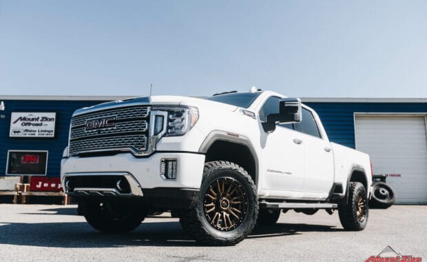 GMC Sierra 2500 with COGNITO 3” lift on Fuel REBEL 8 BRONZE 20x9 +01 Wheels andToyo Open Country R/T 35x12.50R20 Tires front driver side grille view