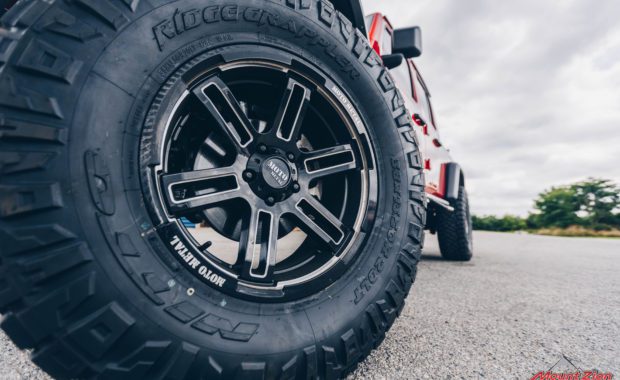Black offroad wheel on Red Jeep Truck