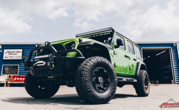 2020 Green Jeep Wrangler with 3.5 Metal Cloak lift kit on Teraflex Nomad Wheels 17x8.5 Deluxe Metallic Black and Nitto Ridge Grappler 37x12.50R17 Tires front driver side grille view