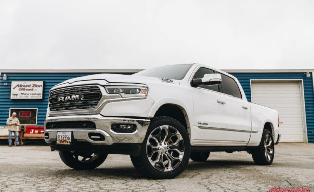 White Ram 1500 with Rough Country 2IN lift on LT285/50R22/10 121/118R NITTO TERRA GRAPPLER G2 tires front driver side grille view